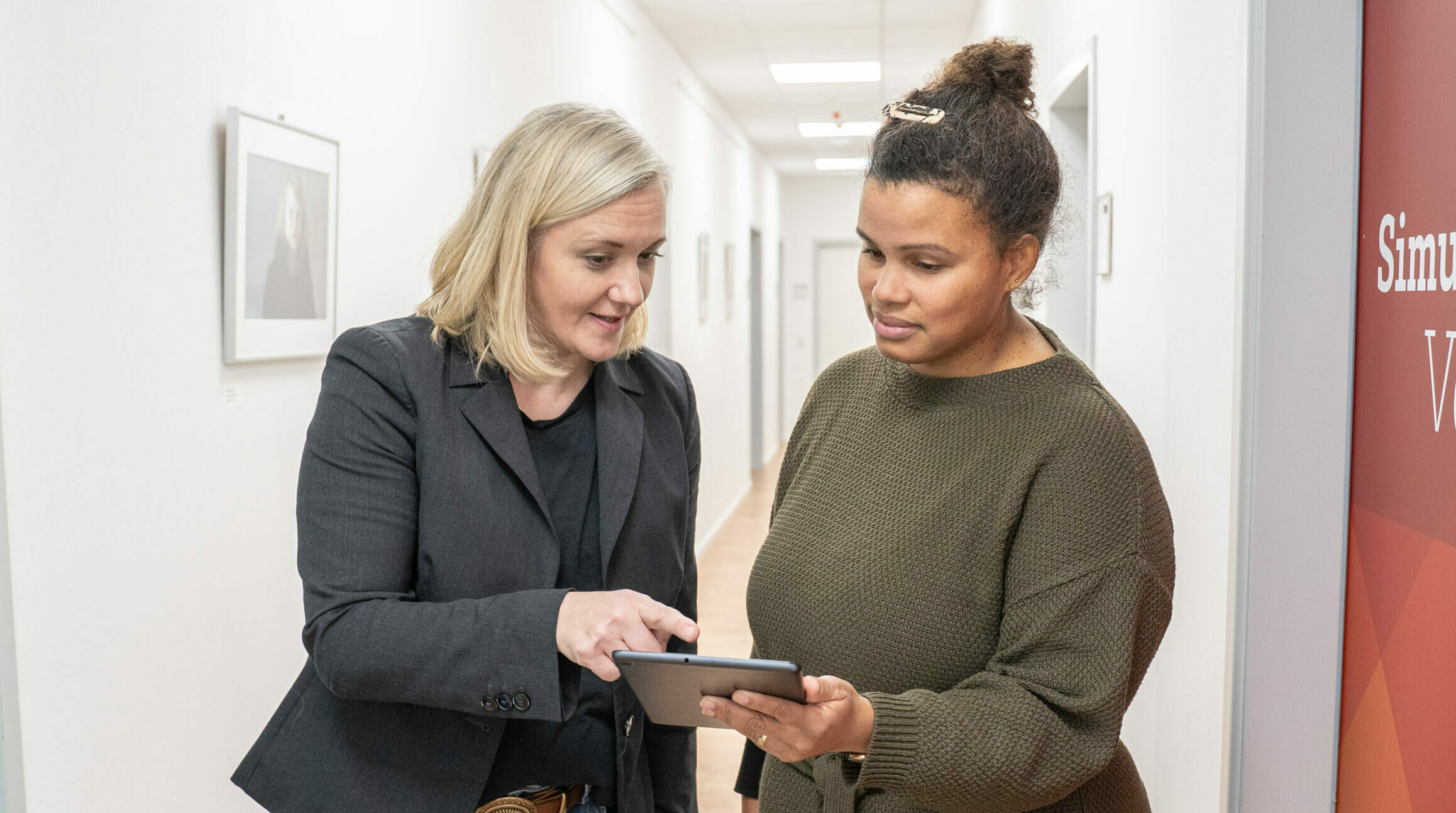 Zwei Personen schauen gemeinsam auf ein Tablet.
