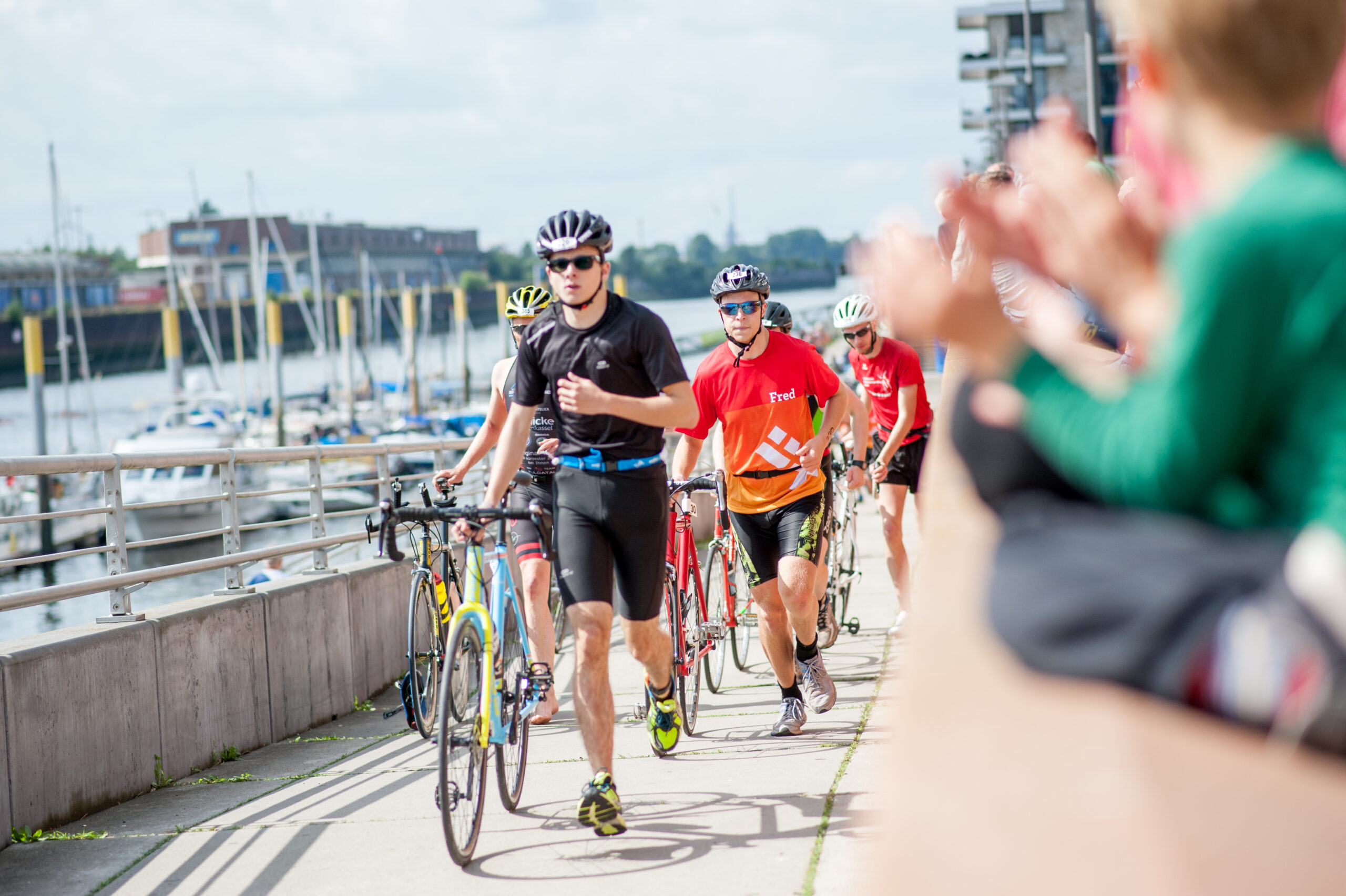 Teilnehmer am Bremer Triathlon werden vom Publikum beklatscht.
