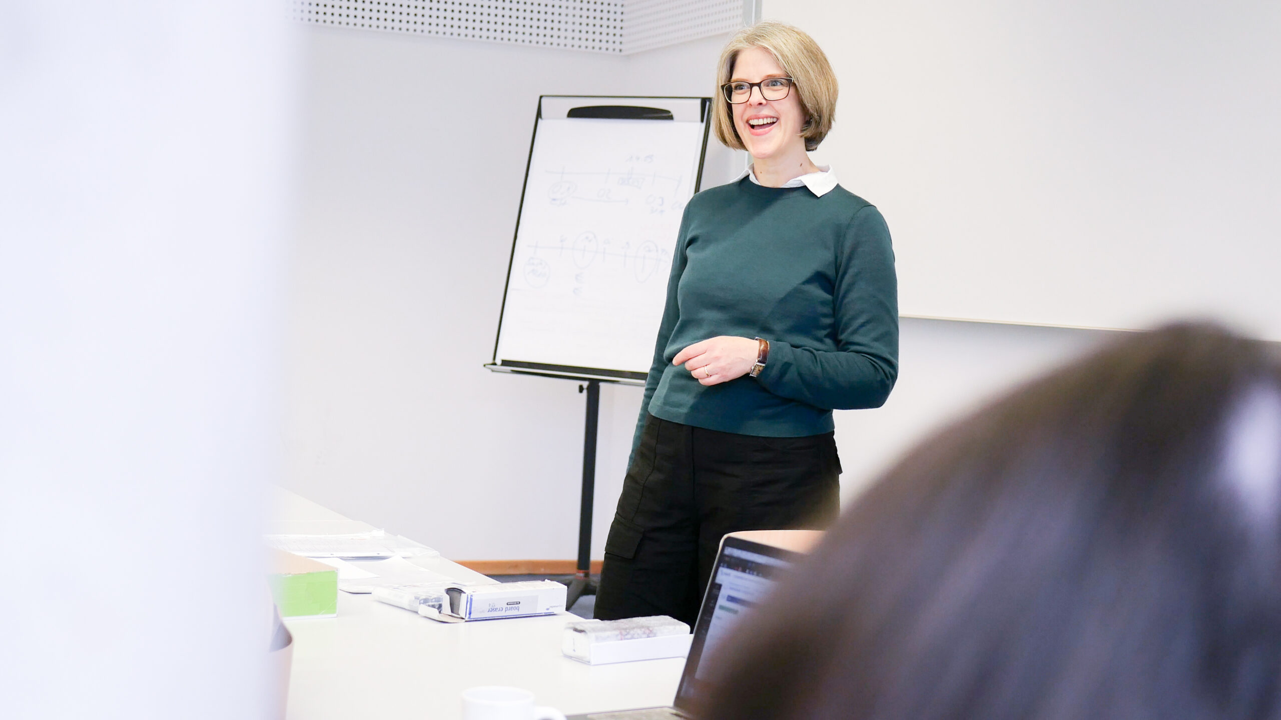 Eine Dozentin präsentiert etwas.