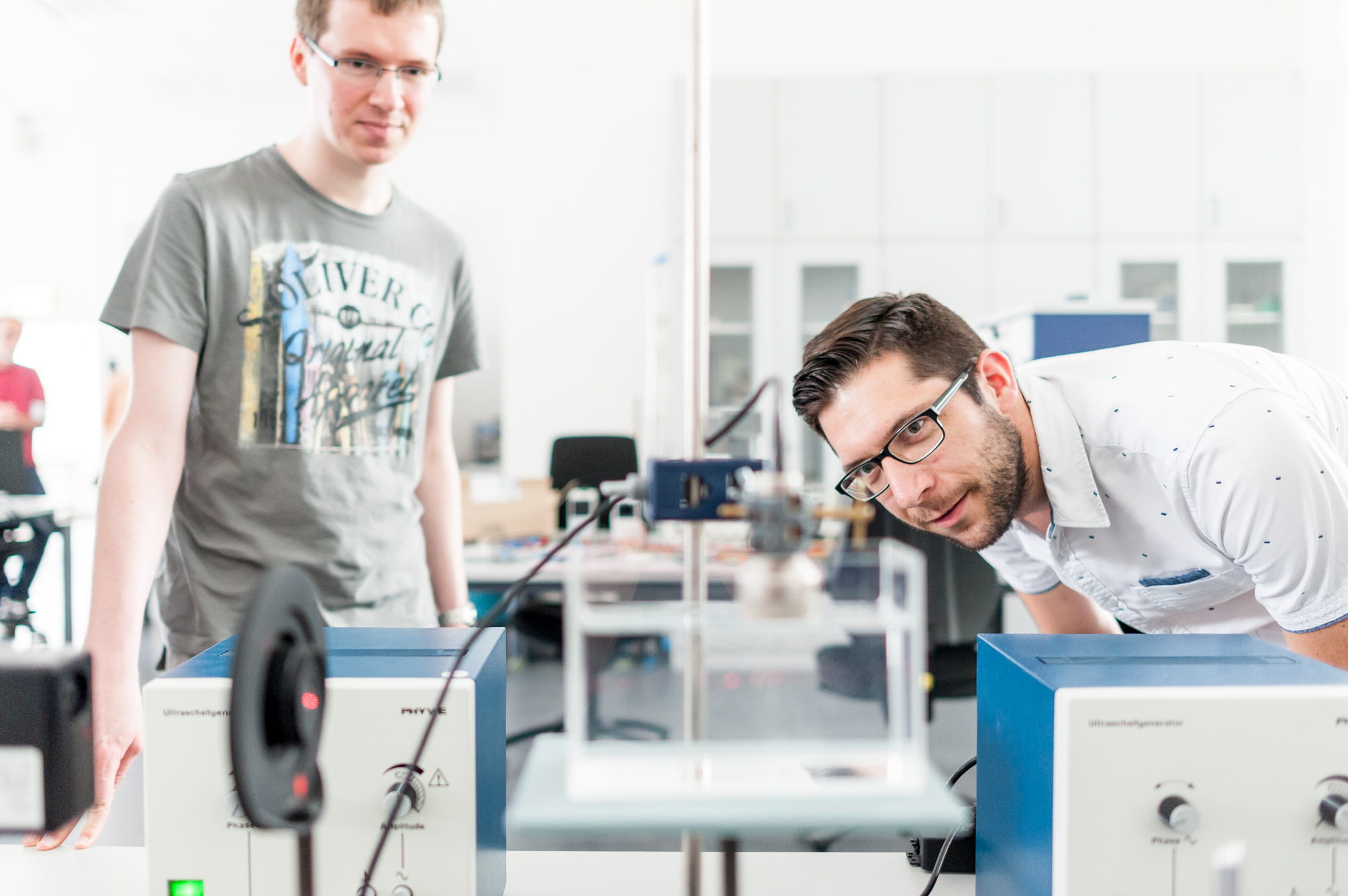 Zwei Menschen betrachten eine technische Apparatur.