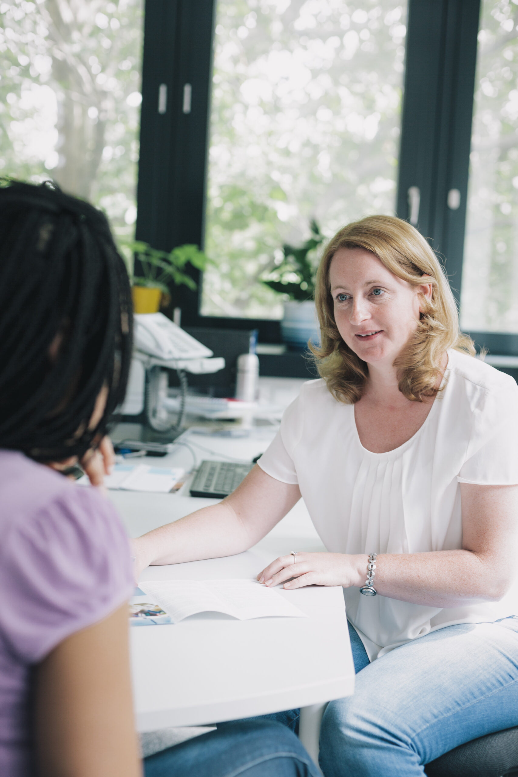 Eine Frau berät eine andere Person.